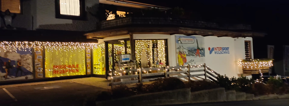 Die Außenfassade des Bergmuseums ist nachts warm beleuchtet und mit festlichen Lichterketten geschmückt. Die leuchtend gelbe Fensterdekoration sorgt für ein einladendes Licht.
