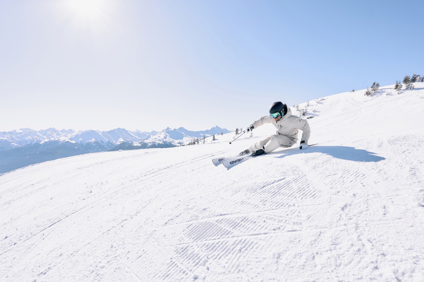 Skifahrer, der an einem sonnigen Tag einen verschneiten Berghang hinunterfährt. Wintersport und alpines Skierlebnis.